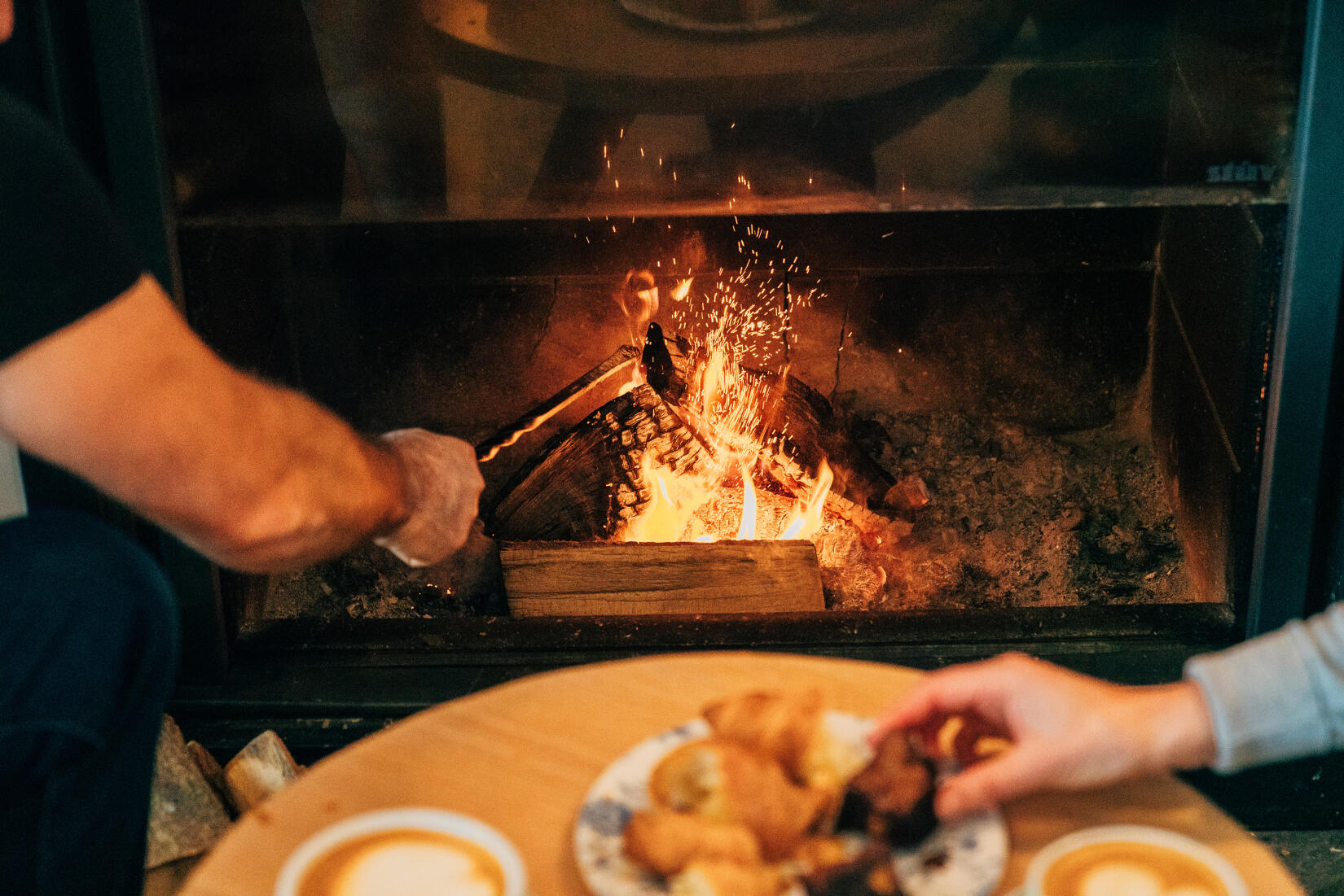 A couple warm up by the log fire in the Ocean Room