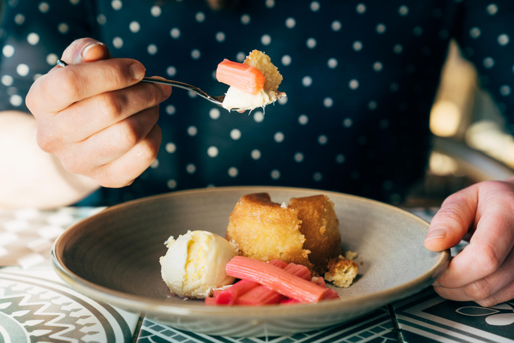 Bowl of lemon drizzle, with cream and rhubarb