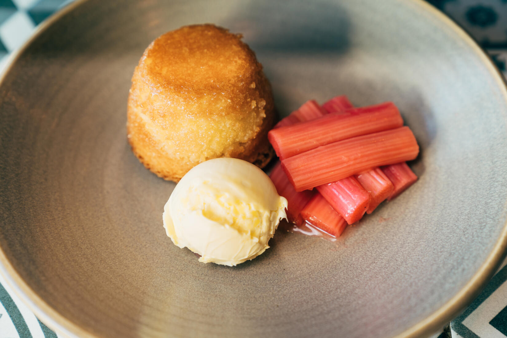 Lemon drizzle dessert next to rhubarb and ice cream