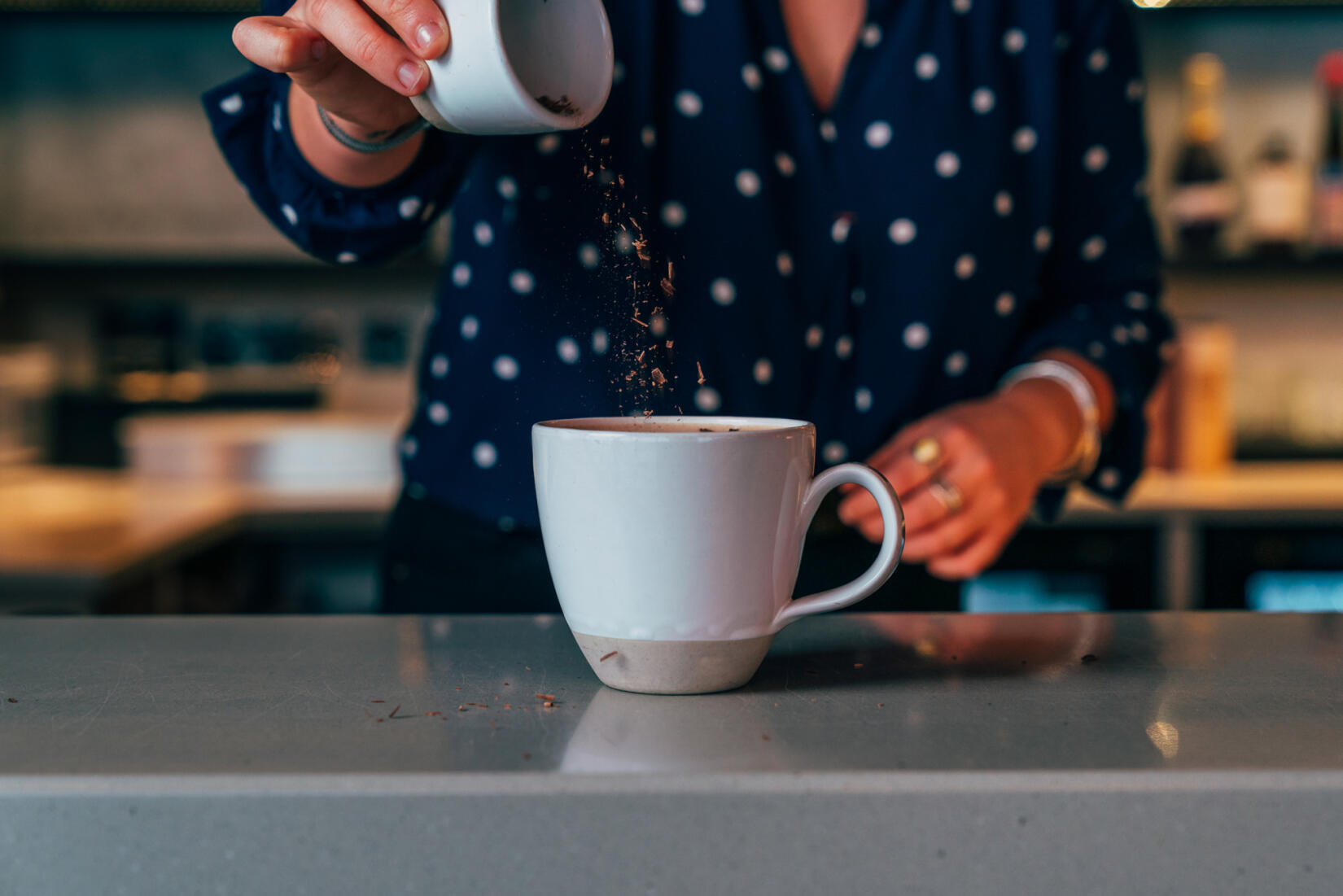 Chocolate sprinkles onto a hot chocolate mug