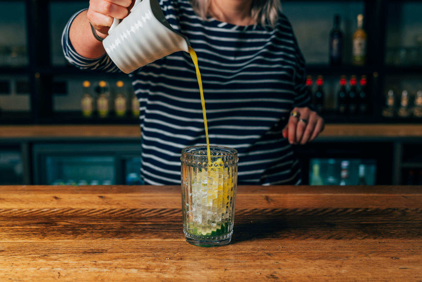 Pouring orange juice into a tumbler for a cocktail