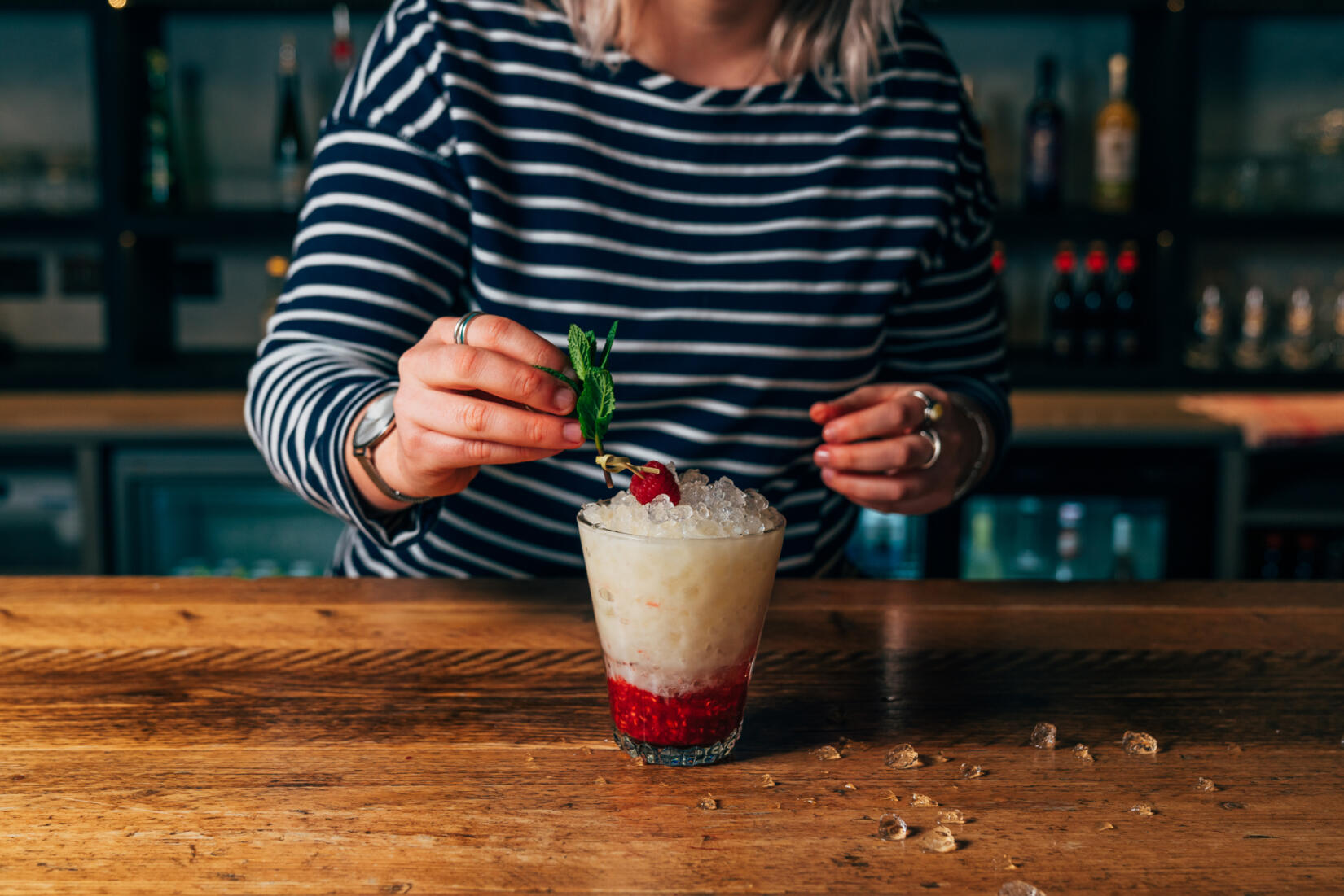 Raspberry gin cocktail in short glass with ice and cherry