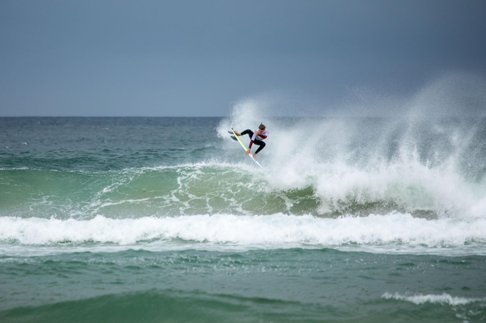 A surfer rides a wave