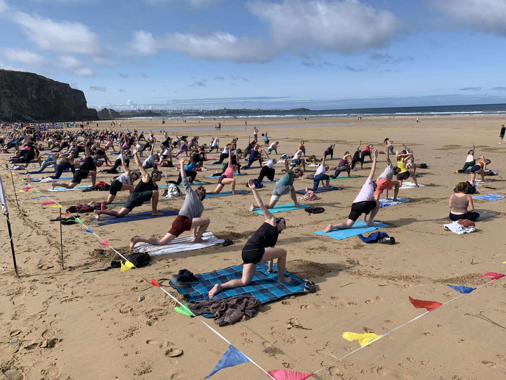 A group of people practice yoga on the beach