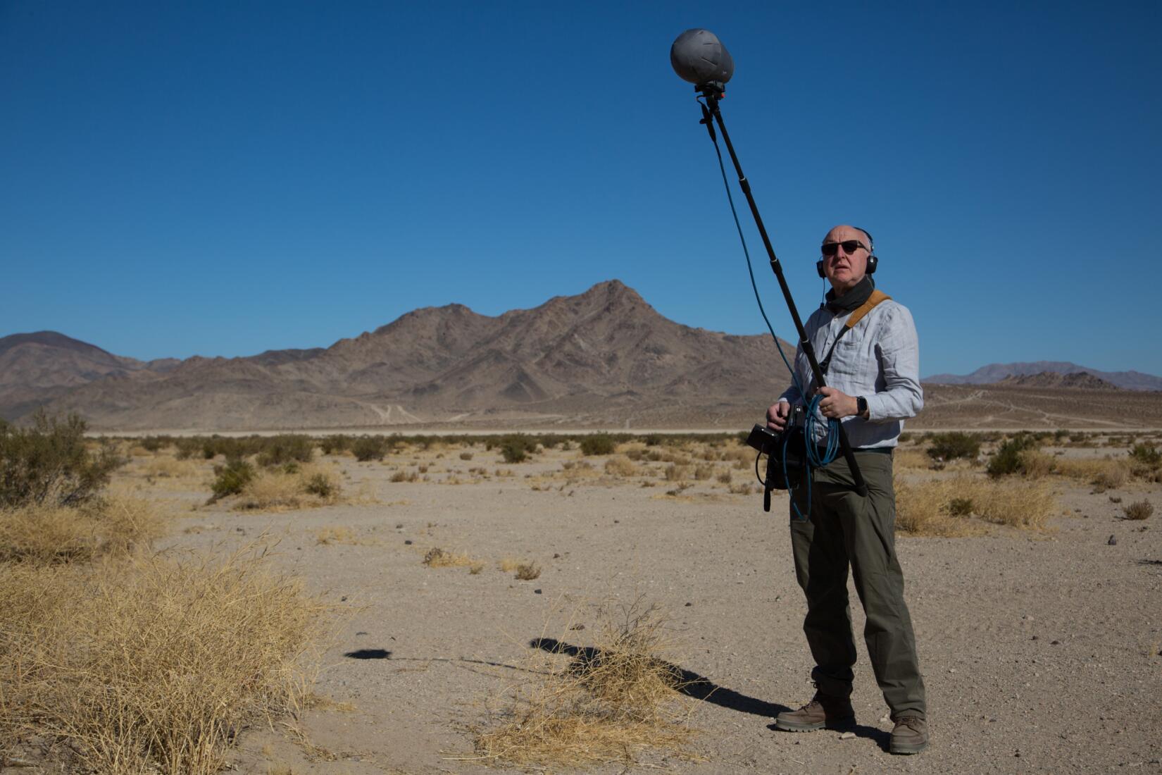 Chris Watson with a boom mic in the desert