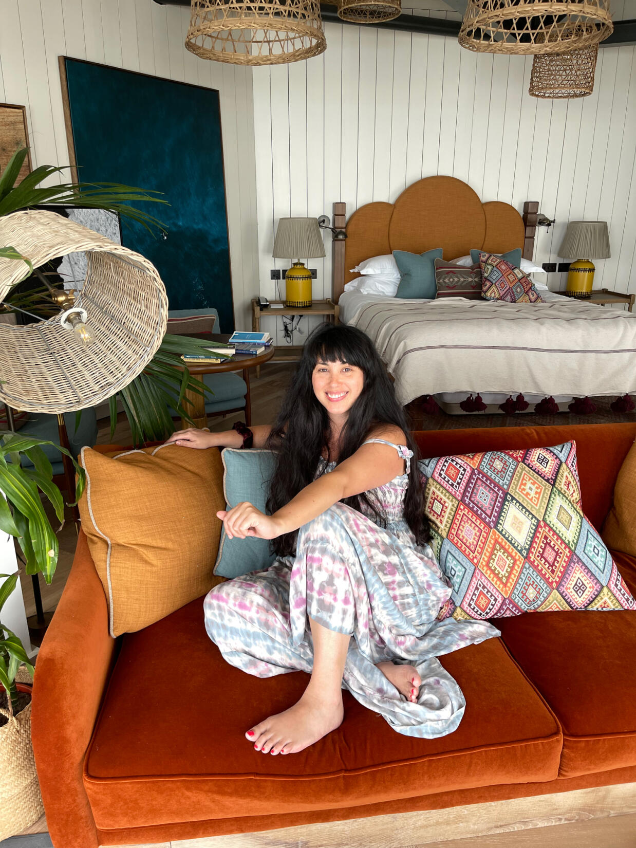 Melissa Hemsley sat on an orange velvet sofa in a beach loft room