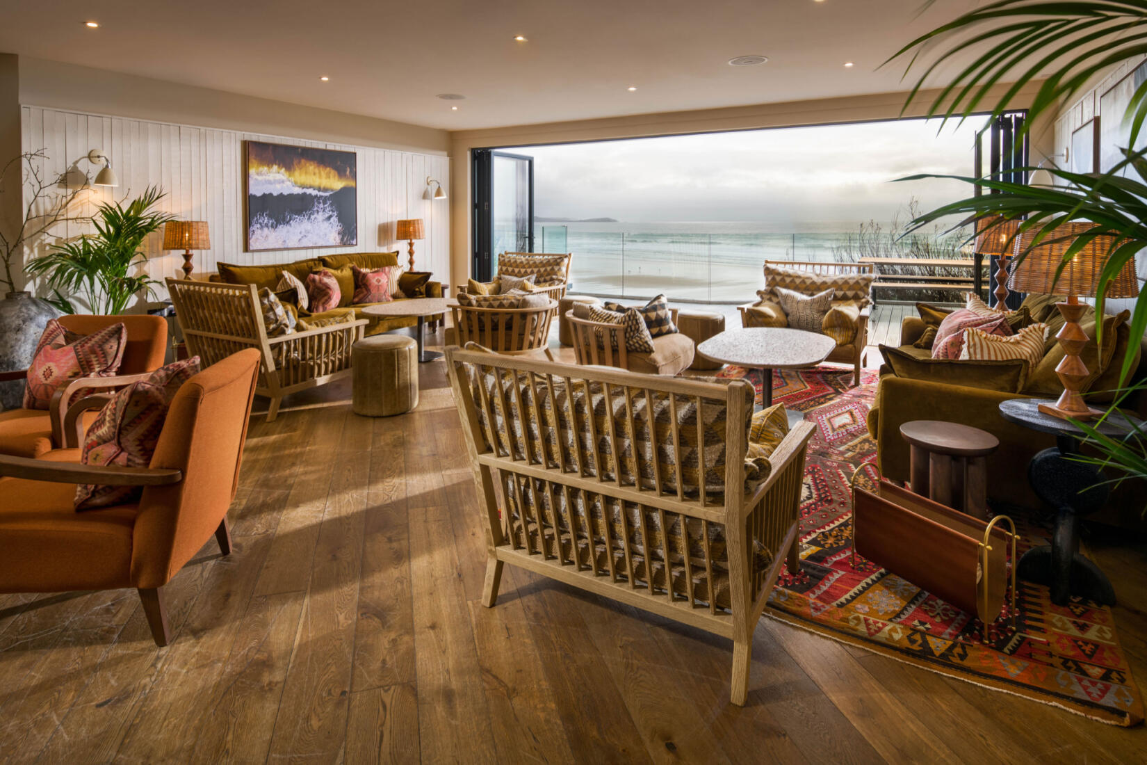 A snug area with chairs and tables facing a sea view