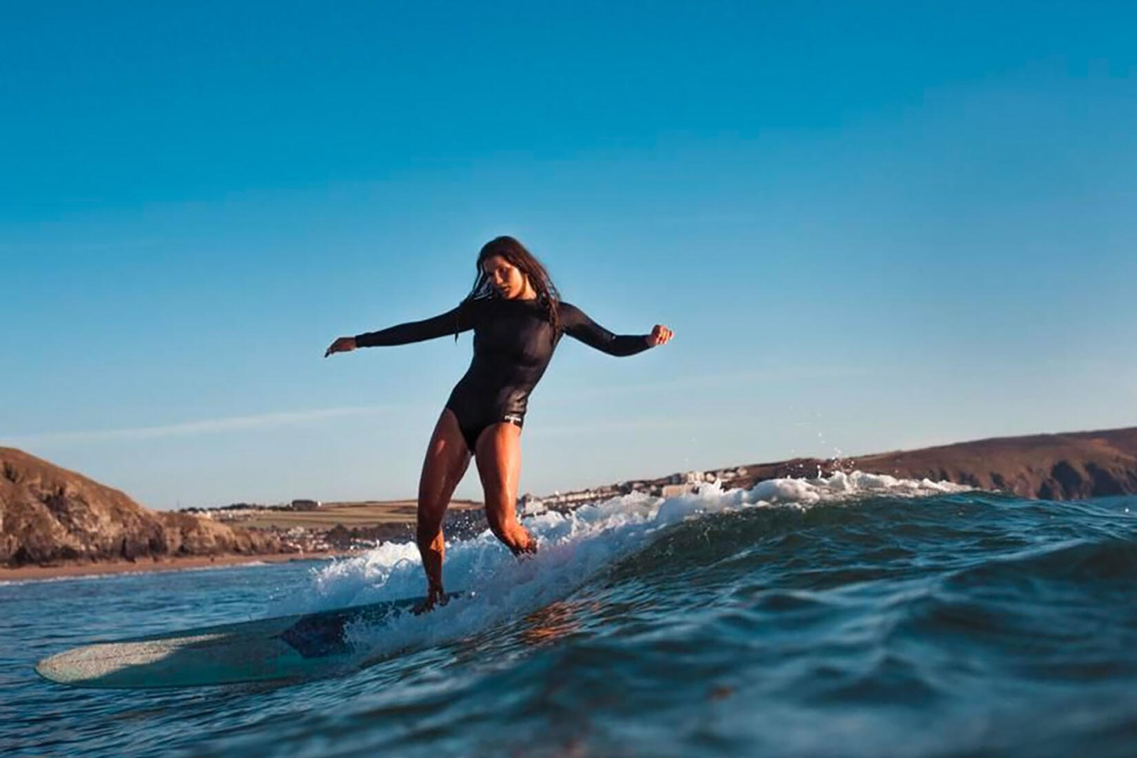 Clara Jones on a surfboard riding a wave