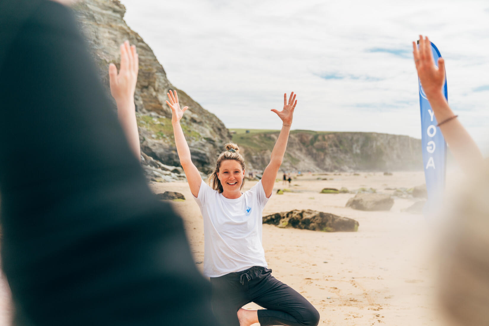 Holly from Wavehunters holds her hands up in tree pose