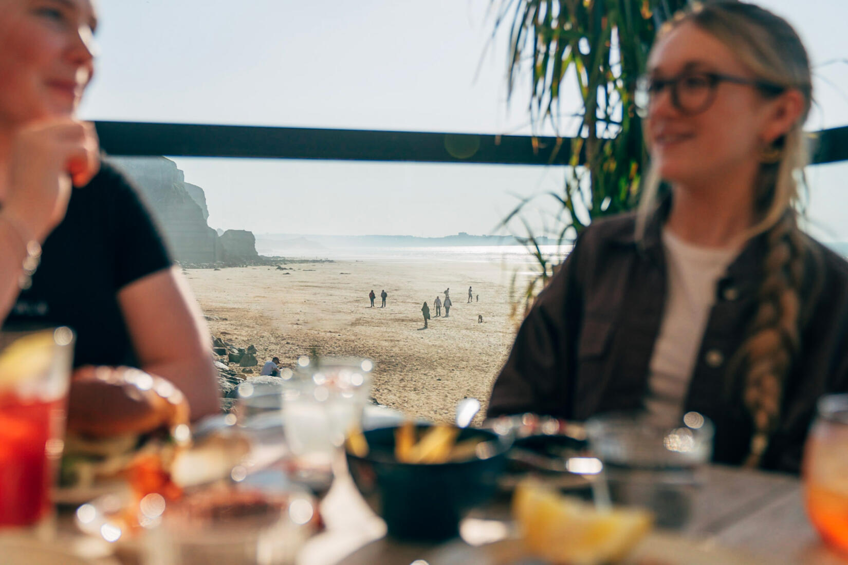 Two friends enjoy lunch on the sea view deck in the Beach Hut