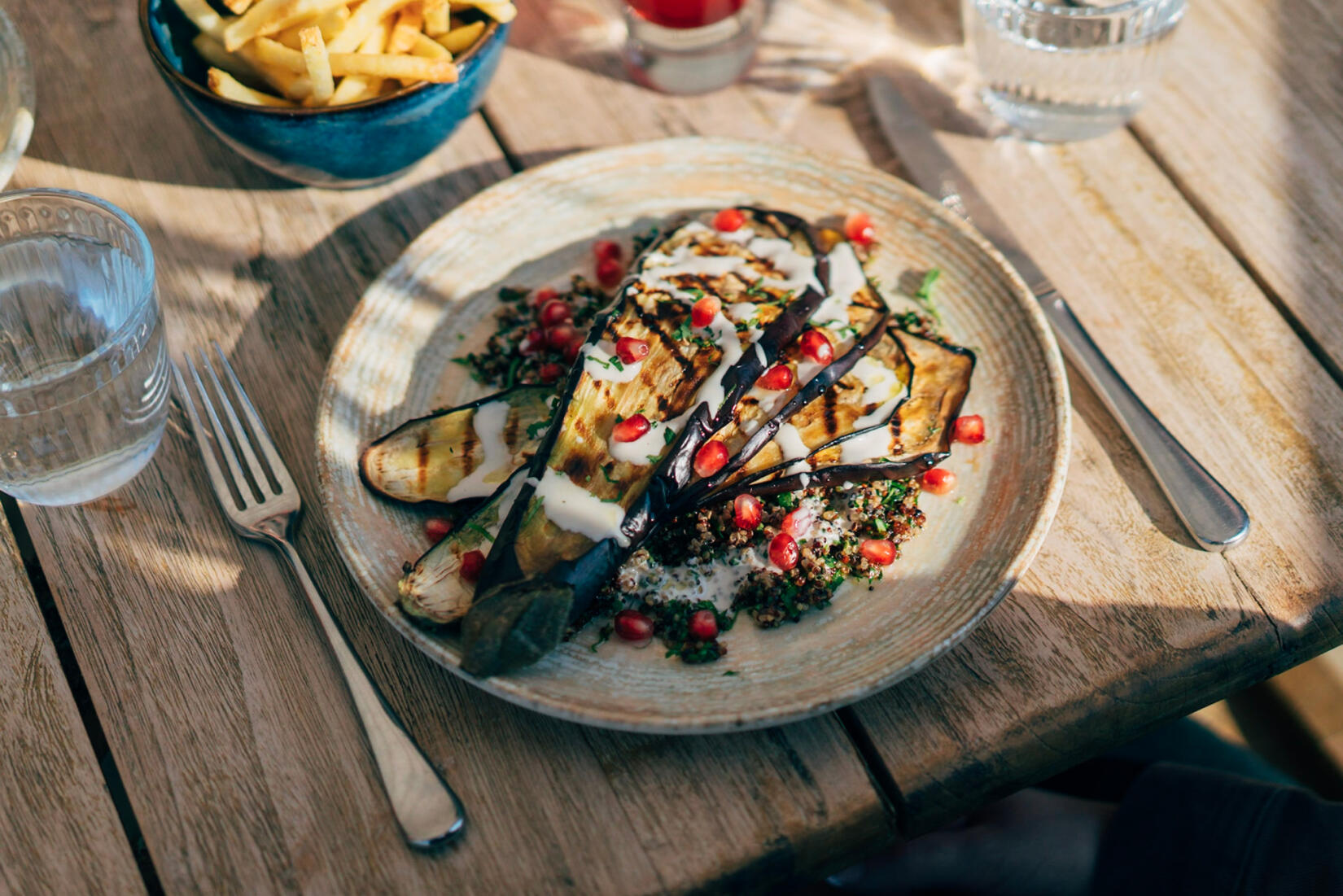 Grilled aubergine and tahini with quinoa, herbs, pomegranate, good oil and crisply shallots