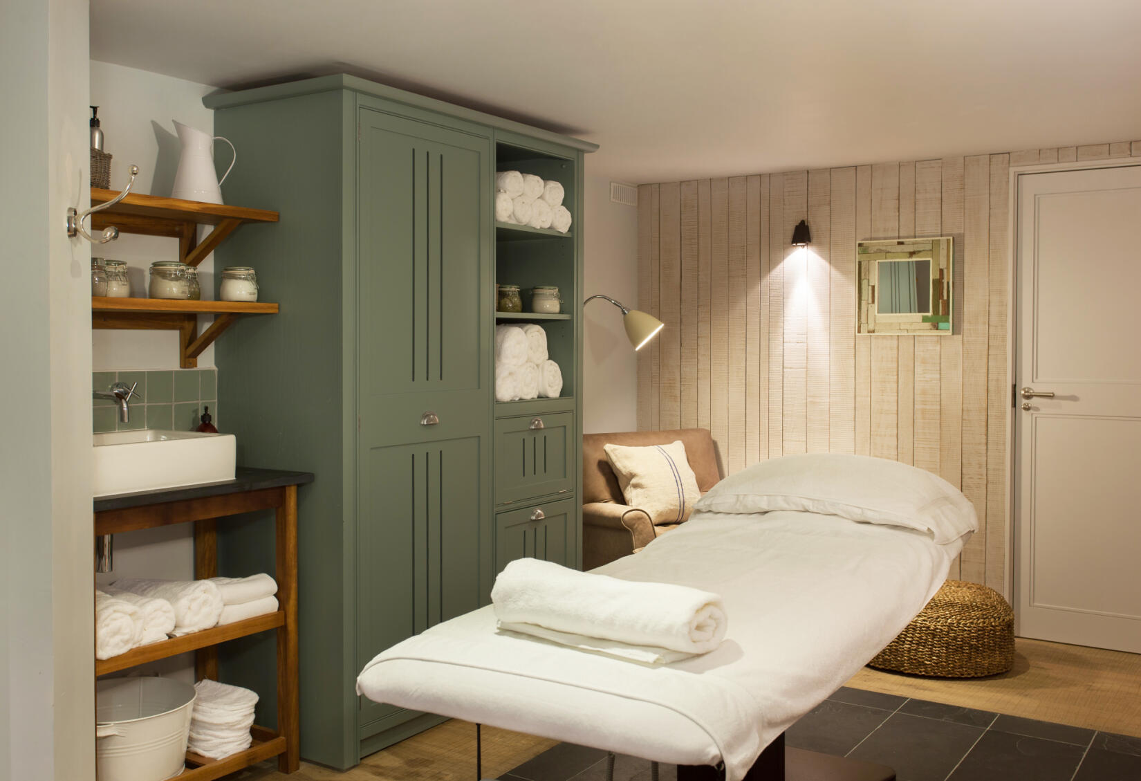 A spa treatment room showing an empty massage bed