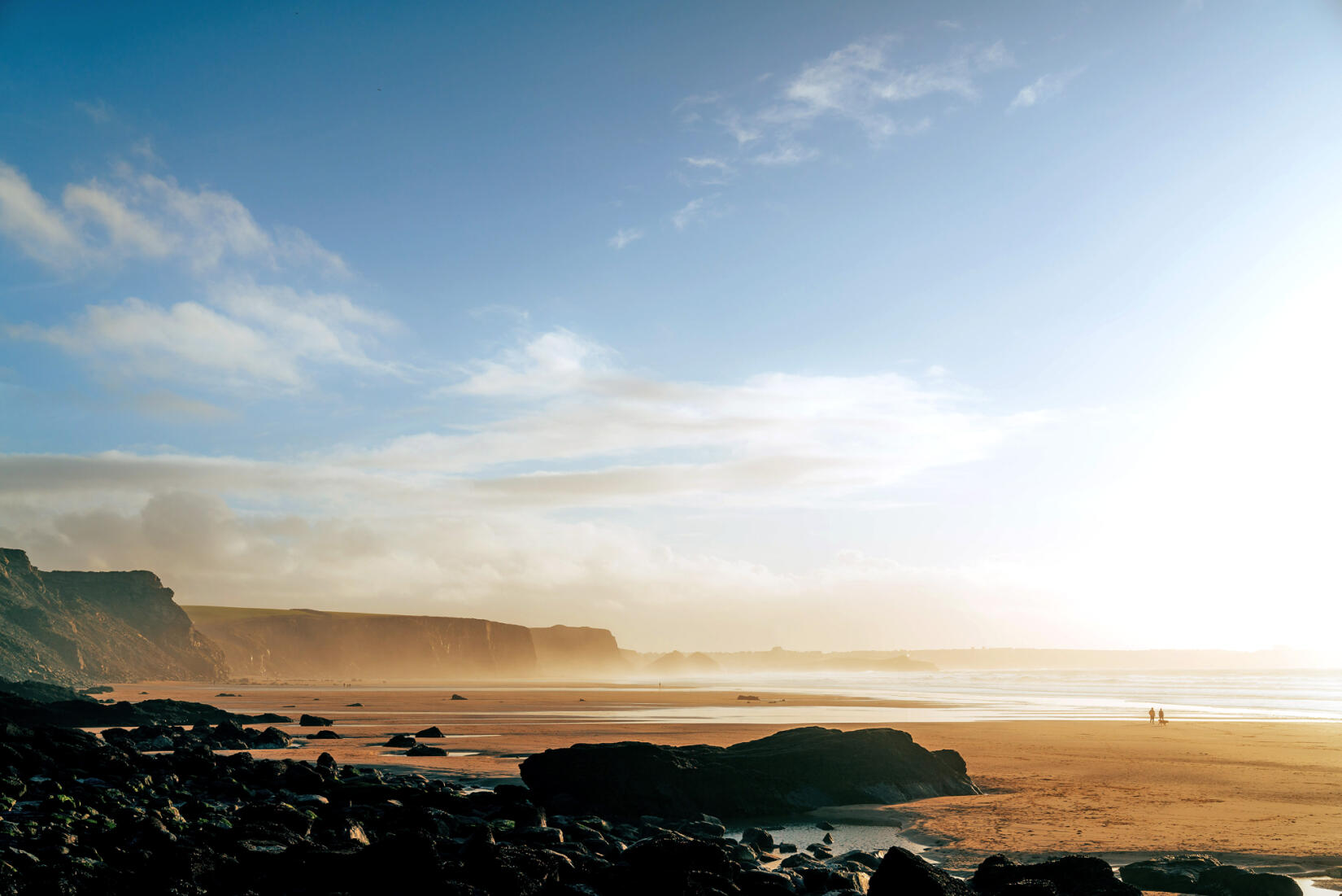 Dog walkers on the beach at Watergate Bay in winter