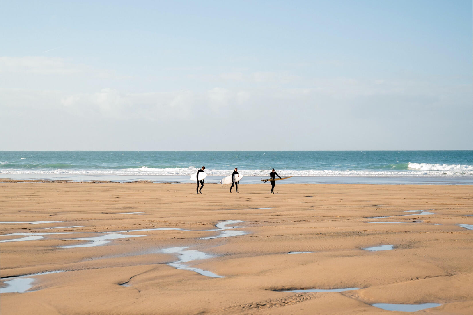 Three friends return to the beach after a surf at Watergate Bay