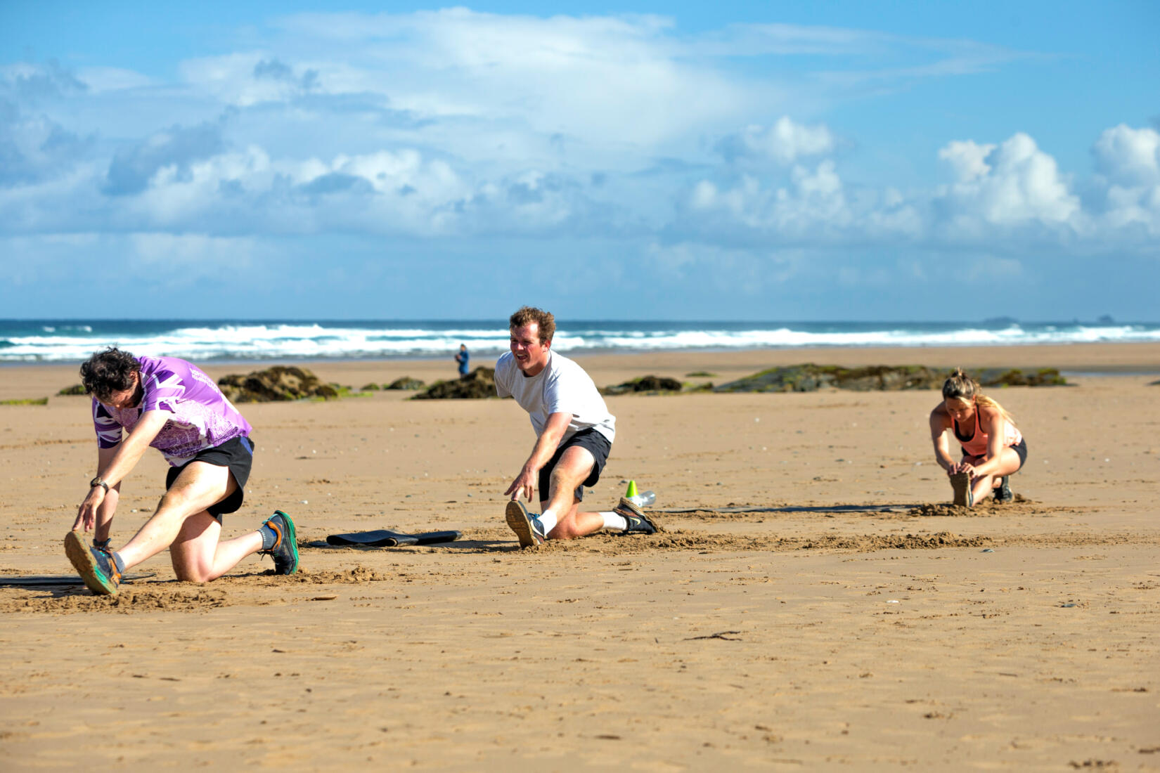 A group stretches in a HIIT class from Wavehunters at Watergate Bay