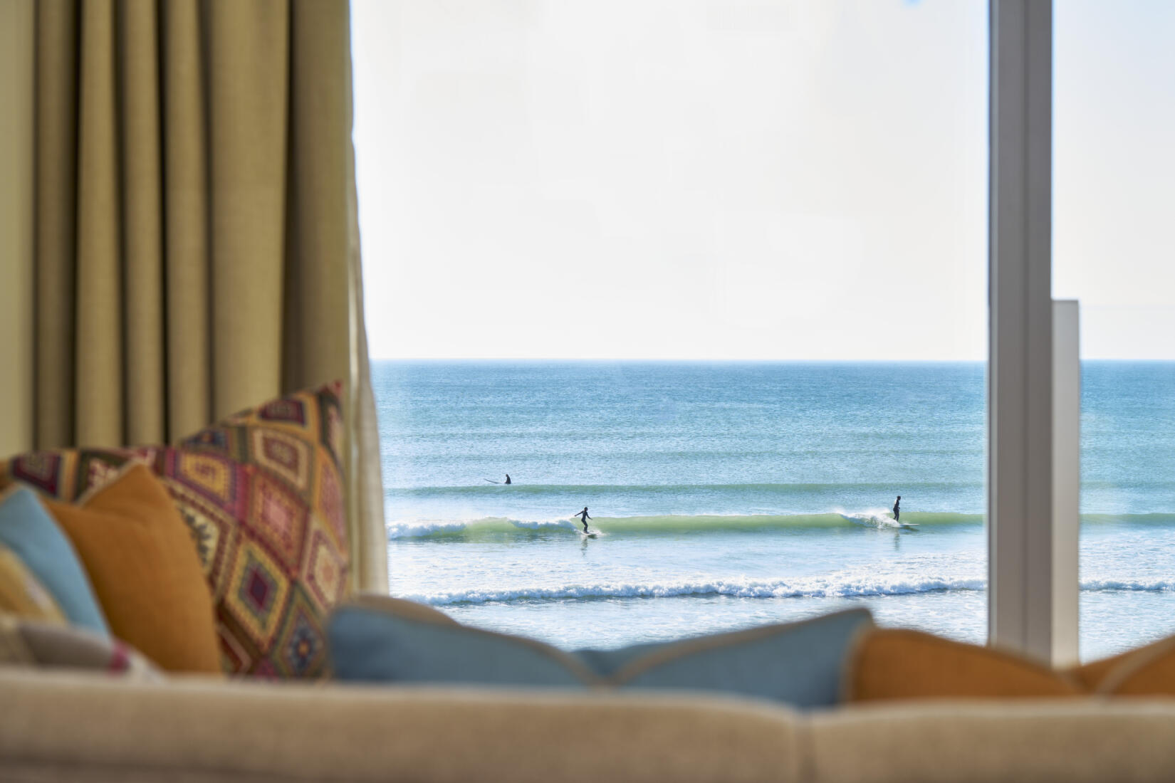 Surfers in the sea out the window of 104