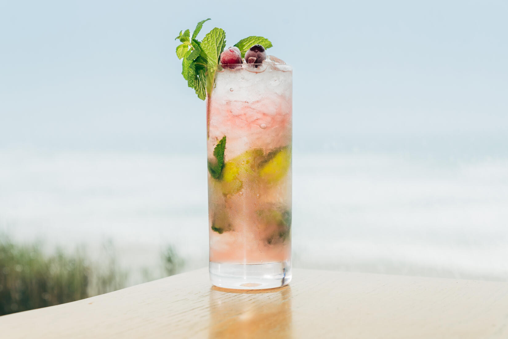 Coconut and cranberry mojito with sea view in the background