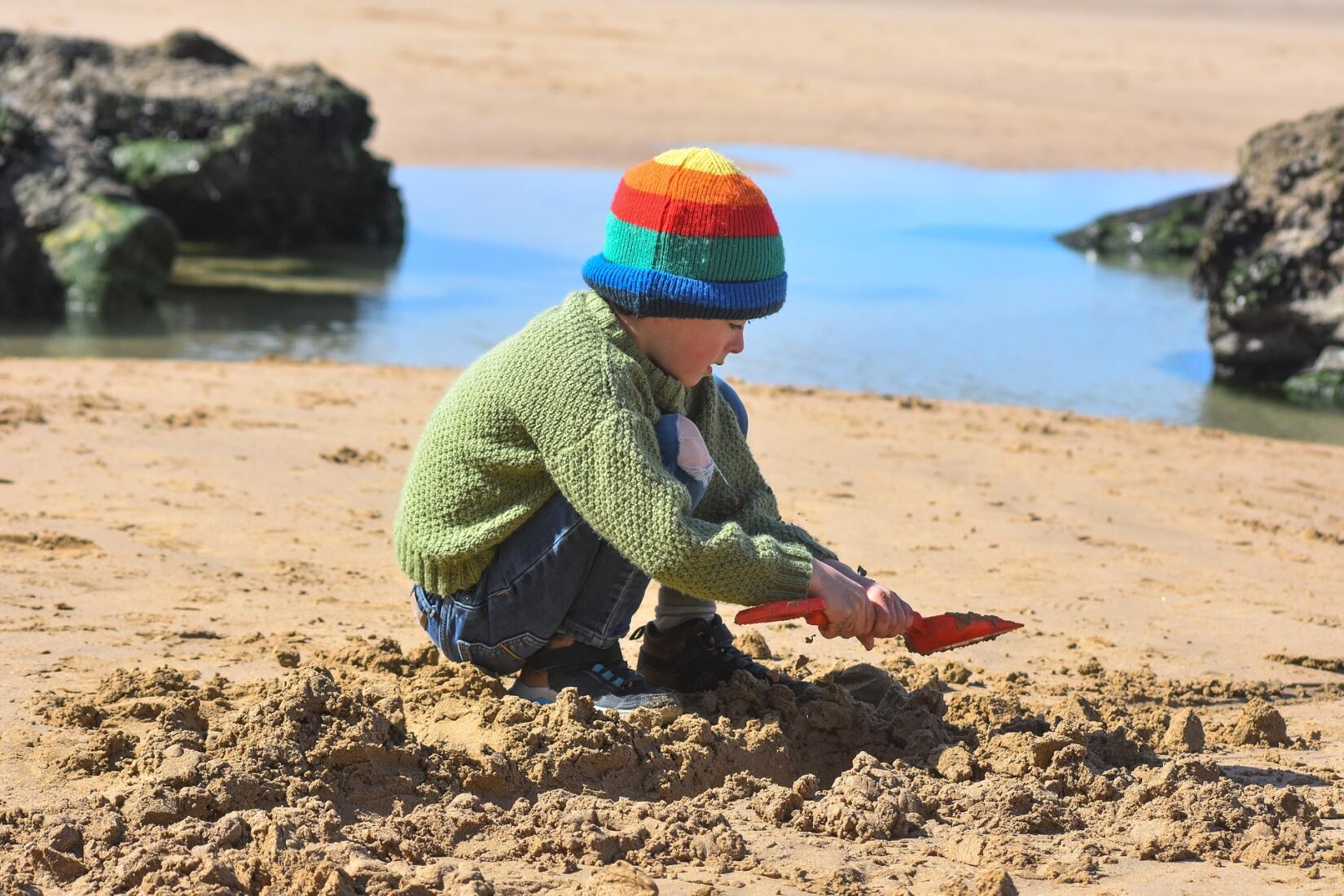 Child using a bucket and spade on the beach