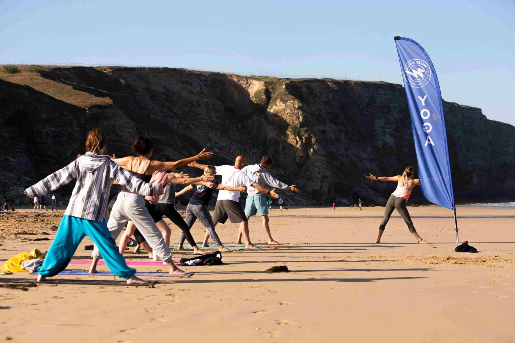 People doing Yoga on the beach with Wavehunters
