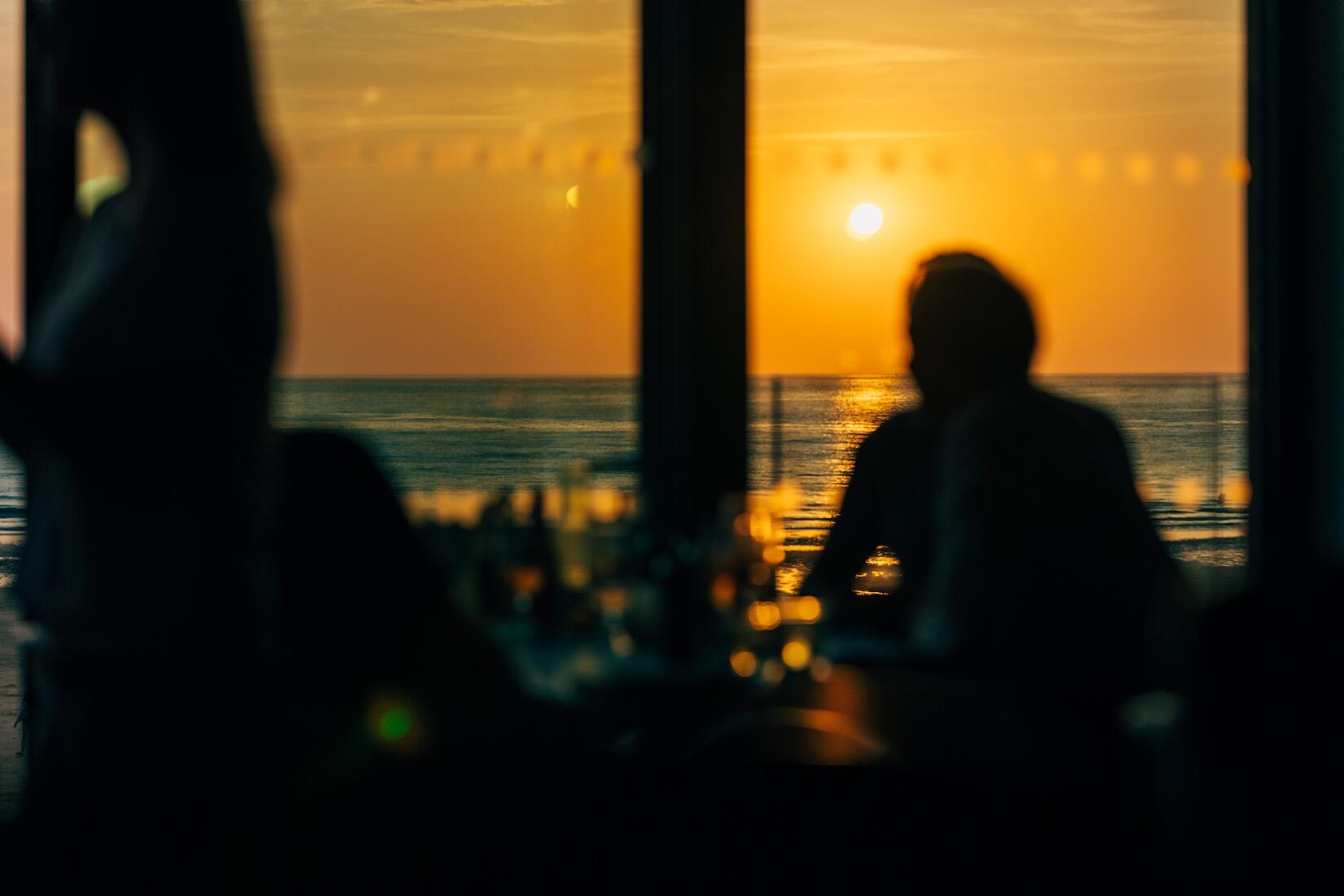 Sunset over the sea looking out of the window from Zacry's on the sea wall