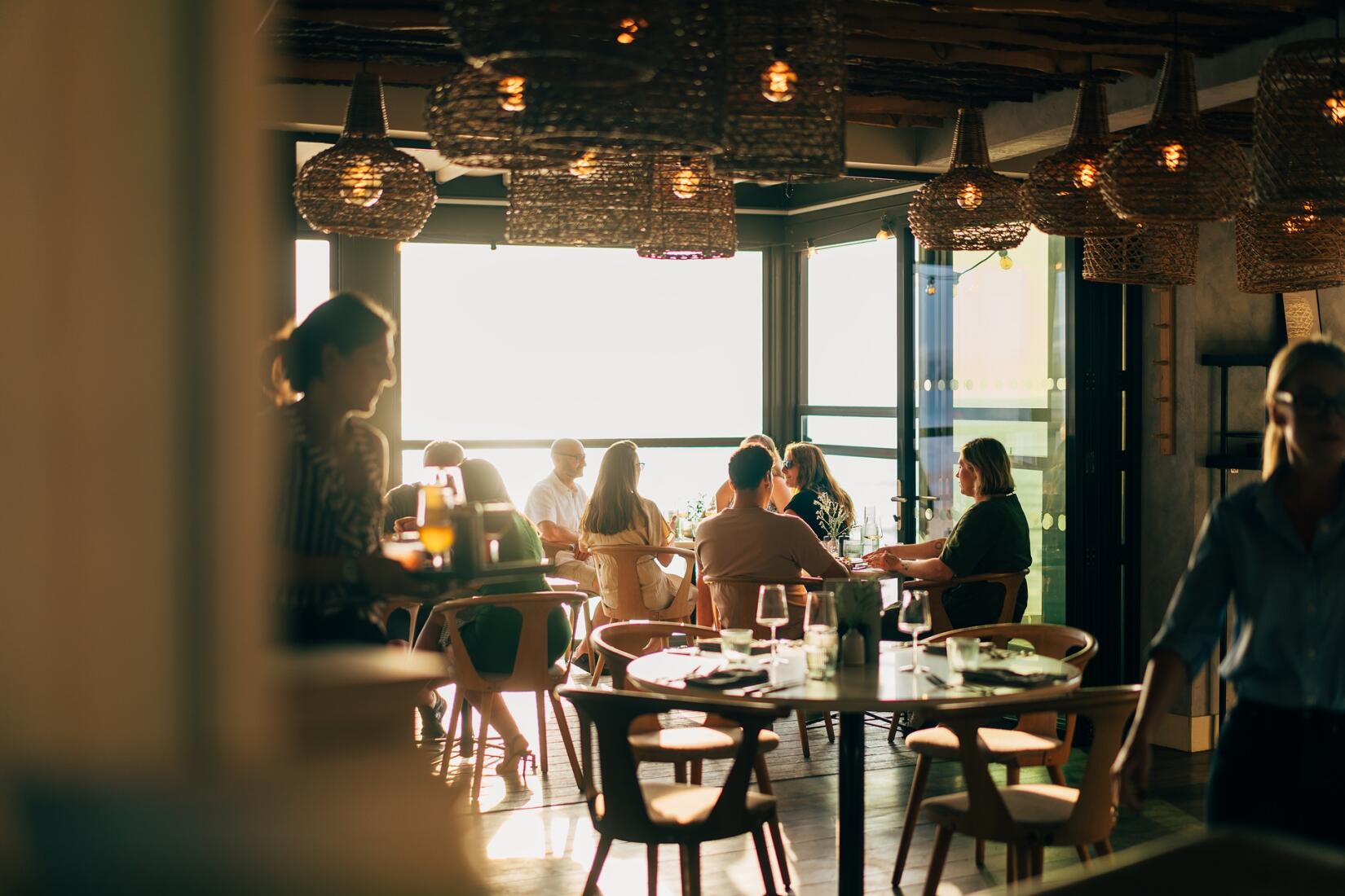 People dining at Zacry's on the sea wall during golden hour